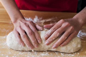 Preparing bread at home: woman hands kneading dough