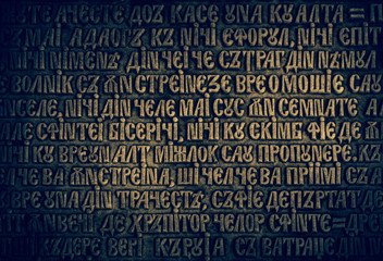 Ancient textured background with slavic text on stone wall.