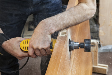 Drilling the hole for door handle using electric drill, close-up