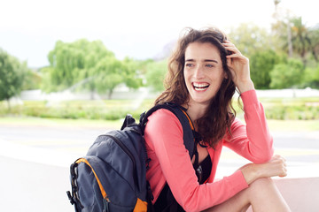 Young travel woman with backpack smiling outside