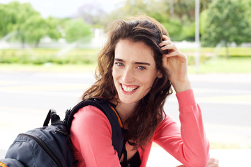 Naklejka premium Smiling young female traveler woman with backpack