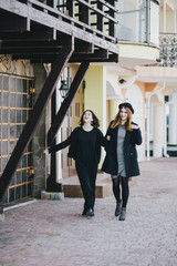 Two young women friends walking on a street