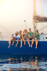 People taking selfies on yacht. Smiling men and women. Weekend with friends. Living the dream.