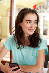 Beautiful woman sitting at a cafe with cellphone