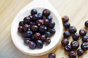 Juniper. Juniper berries on a wooden background. Juniper berry spices on a wooden spoon.