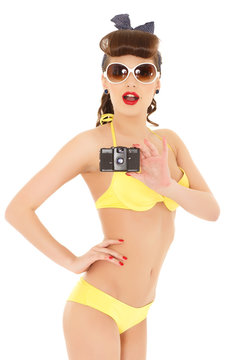 Girl in bikini with retro camera.