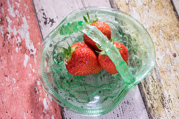 Strawberries in green glass dish from above