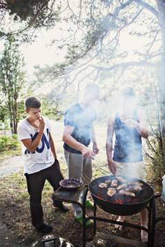 Father with two sons having barbecue
