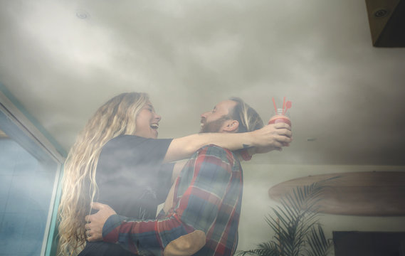 Happy couple embracing in cafe, holding fresh juice