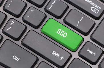 Computer keyboard closeup with "SEO" text on green enter key © okolaa