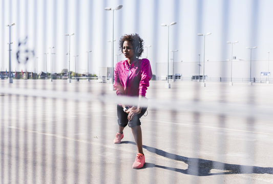 Young woman stretching on parking lot