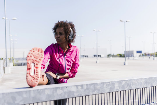 Young woman stretching on parking lot