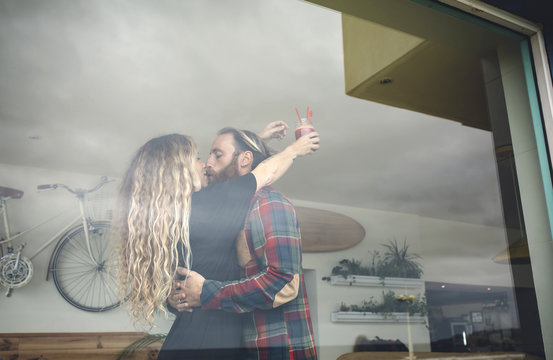 Happy couple embracing in cafe, holding fresh juice