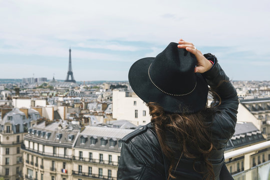 France, Paris, back view of woman at viewpoint wearing a black hat