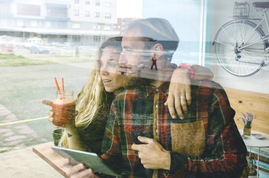 Couple having breakfast at cafe, using digital tablet