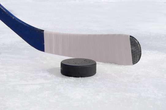 ice hockey stick with white tape and puck