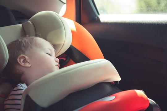 Baby sleeping in car safety seat while travelling