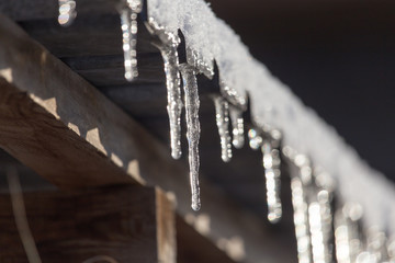 Long and dangerous icicles on a house roof - obrazy, fototapety, plakaty