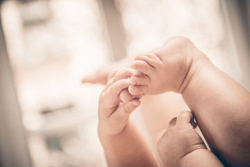 Baby holds his small hands their feet close-up and copy space good as background