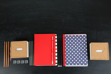 School supplies near blackboard, close up