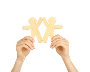 Hands holding a couple of wooden figures, isolated on white