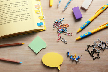 Open book with bookmarks on wooden table