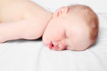 Peaceful baby sleeping in a bed, close up