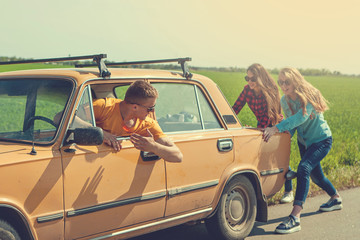 Young hipster friends on road trip on a car