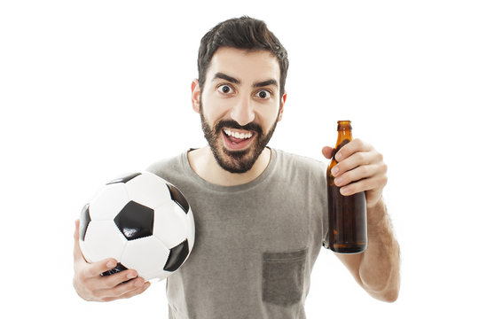 Handsome young man holding ball and beer on white background