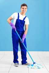 Man holding mop on grey background