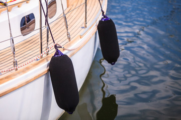 Side of hull sailboat with black fenders