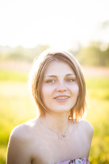 Fototapeta premium Beautiful lady in field at sunset