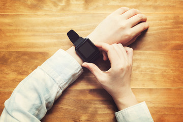 Obraz na płótnie Canvas Person with a smartwatch on a wood table