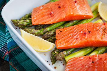 Fresh delicious salmon, green asparagus and lemon in pan
