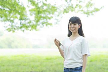 Fototapeta premium スマートフォンで音楽を聞く女性