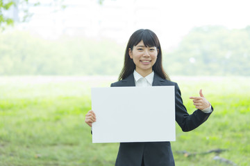 ボードを持つスーツの女性