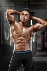 Fototapeta na wymiar Sexy asian muscular man posing in gym, shaped abdominal. Strong male naked torso abs, working out