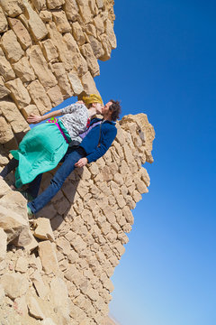 Tourist couple kissing in front of ruined stone house in desert, Egypt.