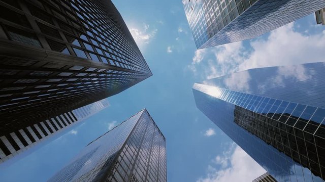 Blue sky and clouds reflecting over skyscrapers facades in Financial District in New York City, low angle, panning