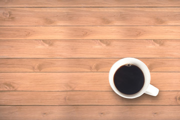 Cup of fresh coffee on wooden table, top view