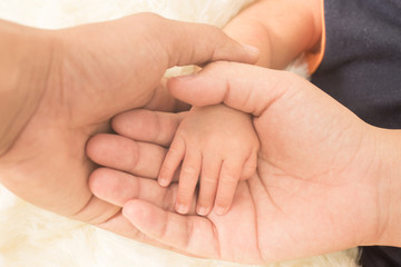 Hand the sleeping baby in the hand of mother close-up (Soft focu