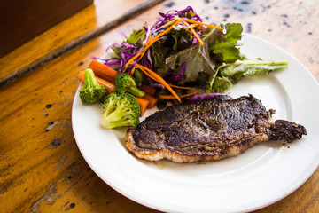 Beef steak with salad on wooden table