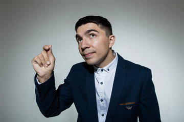 Young attractive businessman snaps his fingers and looking up.
