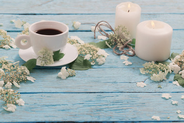 beautiful composition with cup of coffee and white flowers on bl