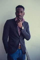 Black man in a suit with watch on wrist.