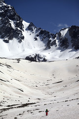 Hiker in snowy mountains at nice spring day