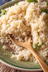 Cooked bulgur with herbs close-up. vertical
