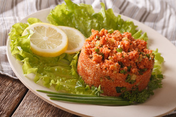 Turkish appetizer spicy kısır of bulgur with herbs on the table. Horizontal
