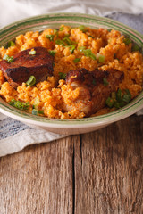 Spicy bulgur with beef close-up on a plate. vertical
