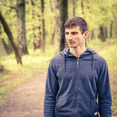 Young sportsman standing on trail after jogging